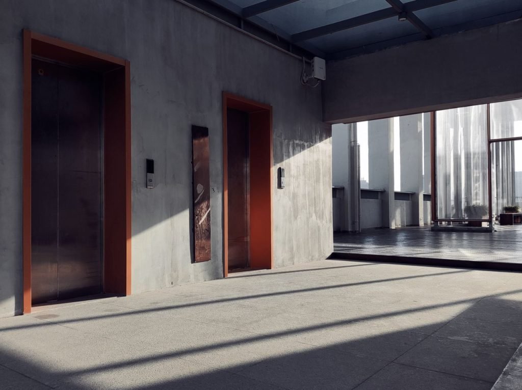 Crafting Captivating Headlines: Your awesome post title goes here A minimalist interior showcasing elevators, sunlight, and striking shadows in a modern hallway.