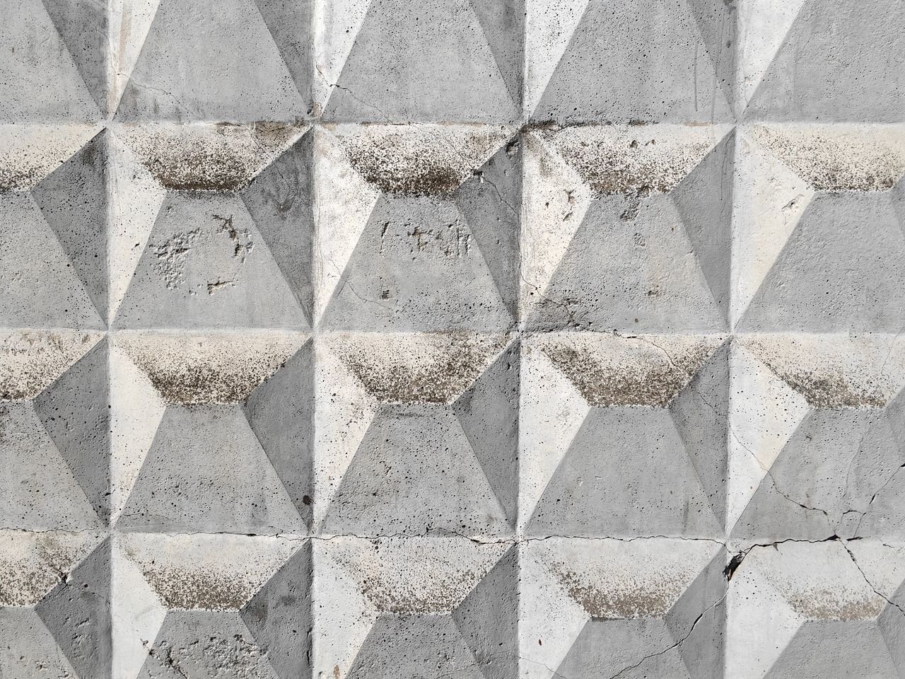 The Art of Drawing Readers In: Your attractive post title goes here Textured geometric concrete wall in Moscow, showcasing a repeating triangular pattern.